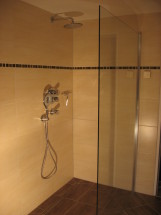 ebenerdige Dusche, Wand beige, Boden braun gefliest